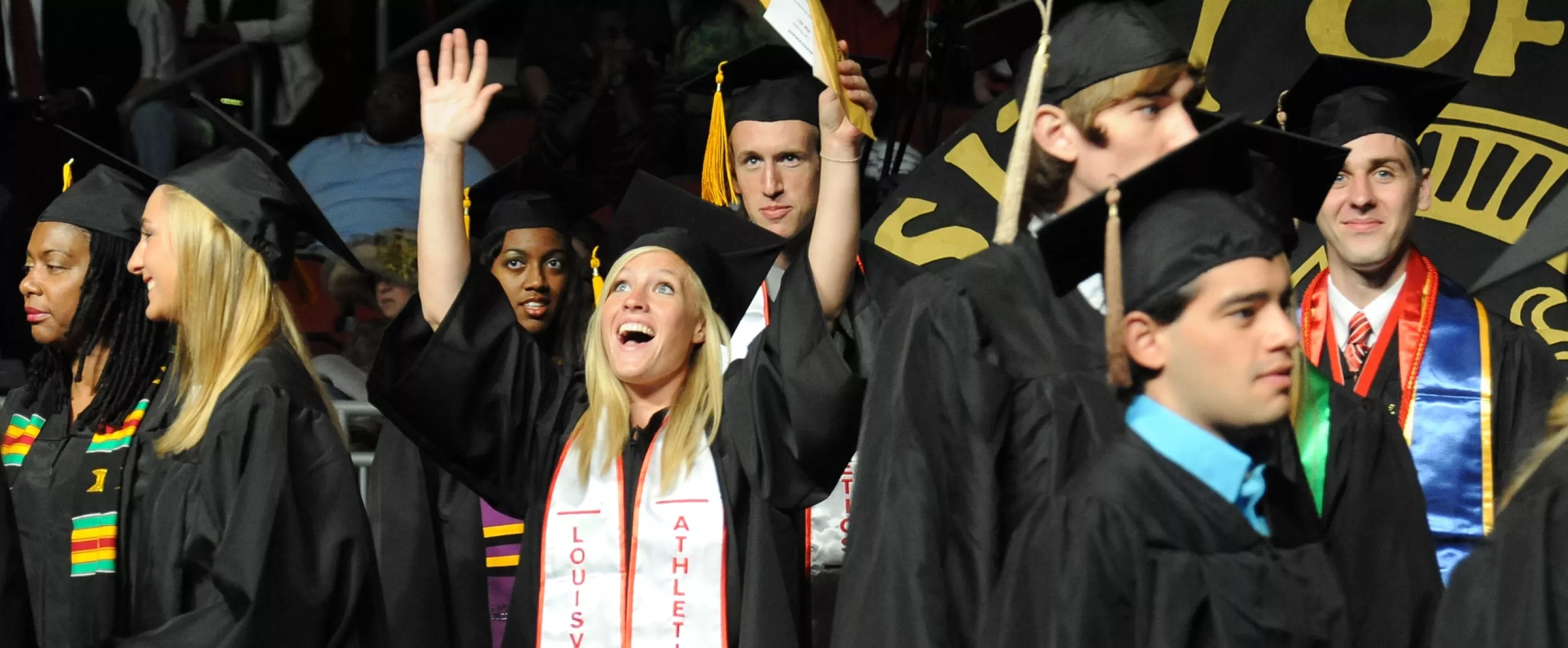 Graduate throws her hands in celebration at graduation