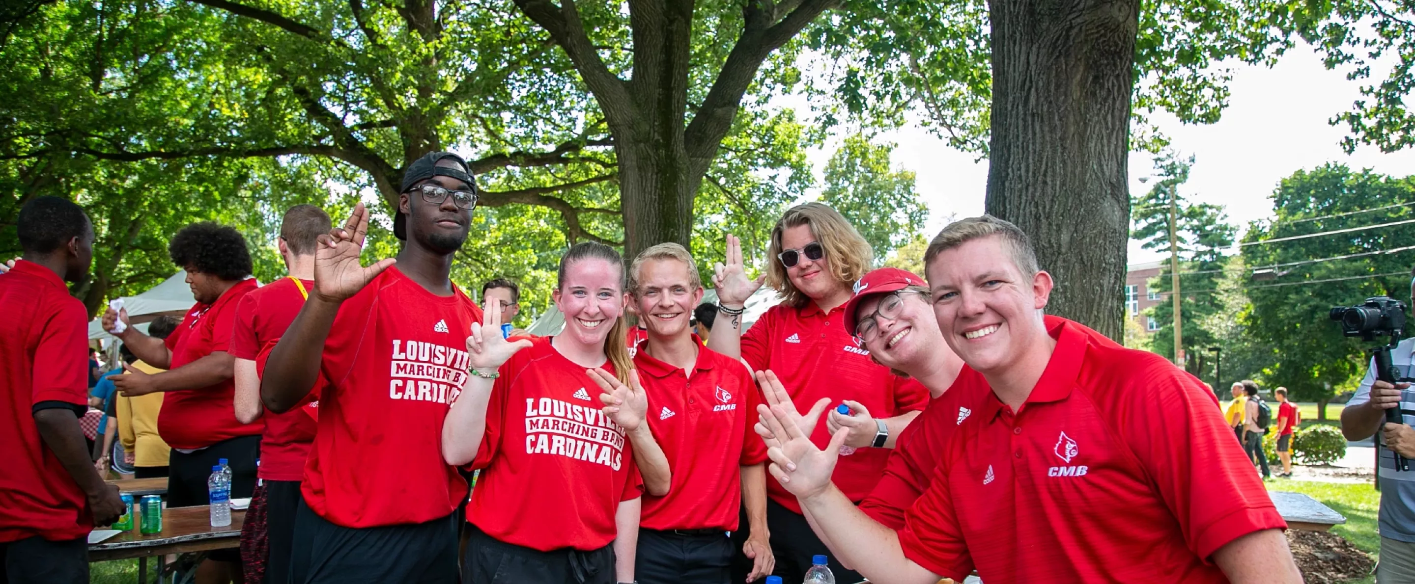 Members of the Cardinal Marching Band pose for a picture holding up their Ls.