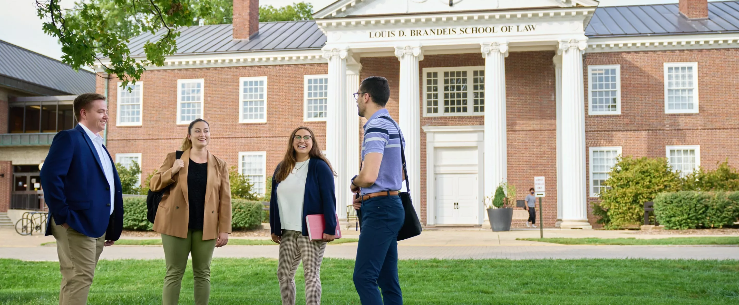 Law students standing in the courtyard of Brandeis School of Law having a socially distanced conversation.