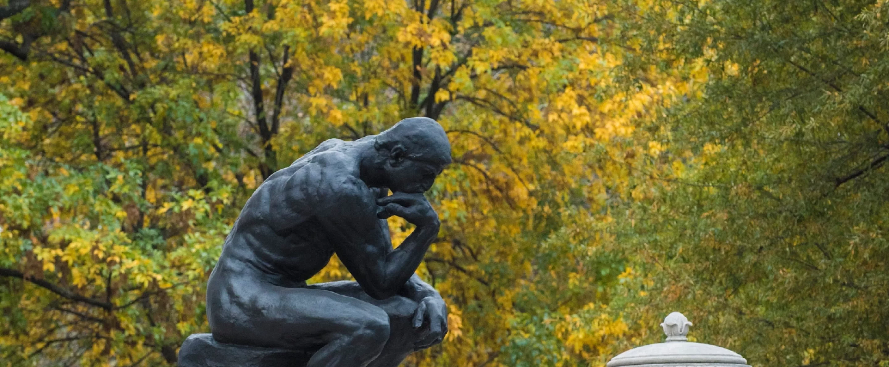 Steps of Grawemeyer Hall and The Thinker against fall trees