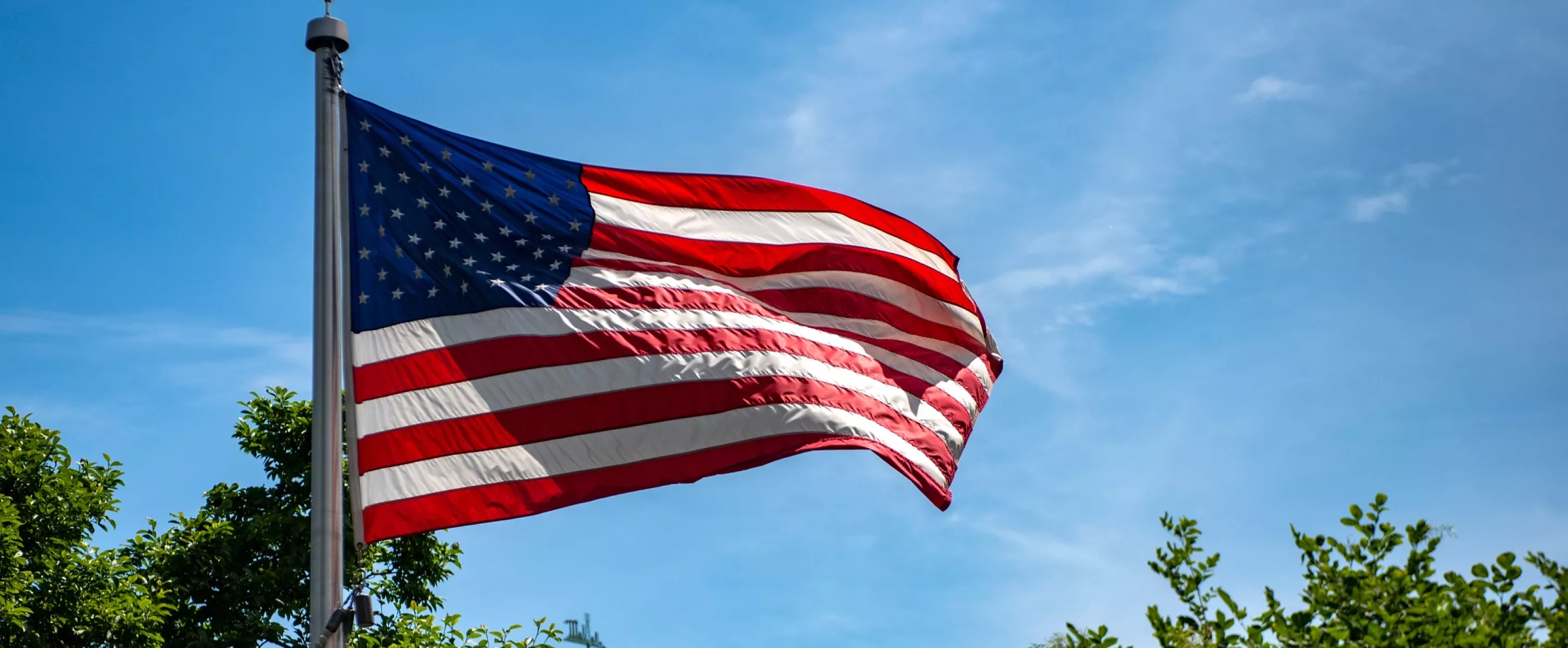 American flag waving in the wind on Belknap Campus