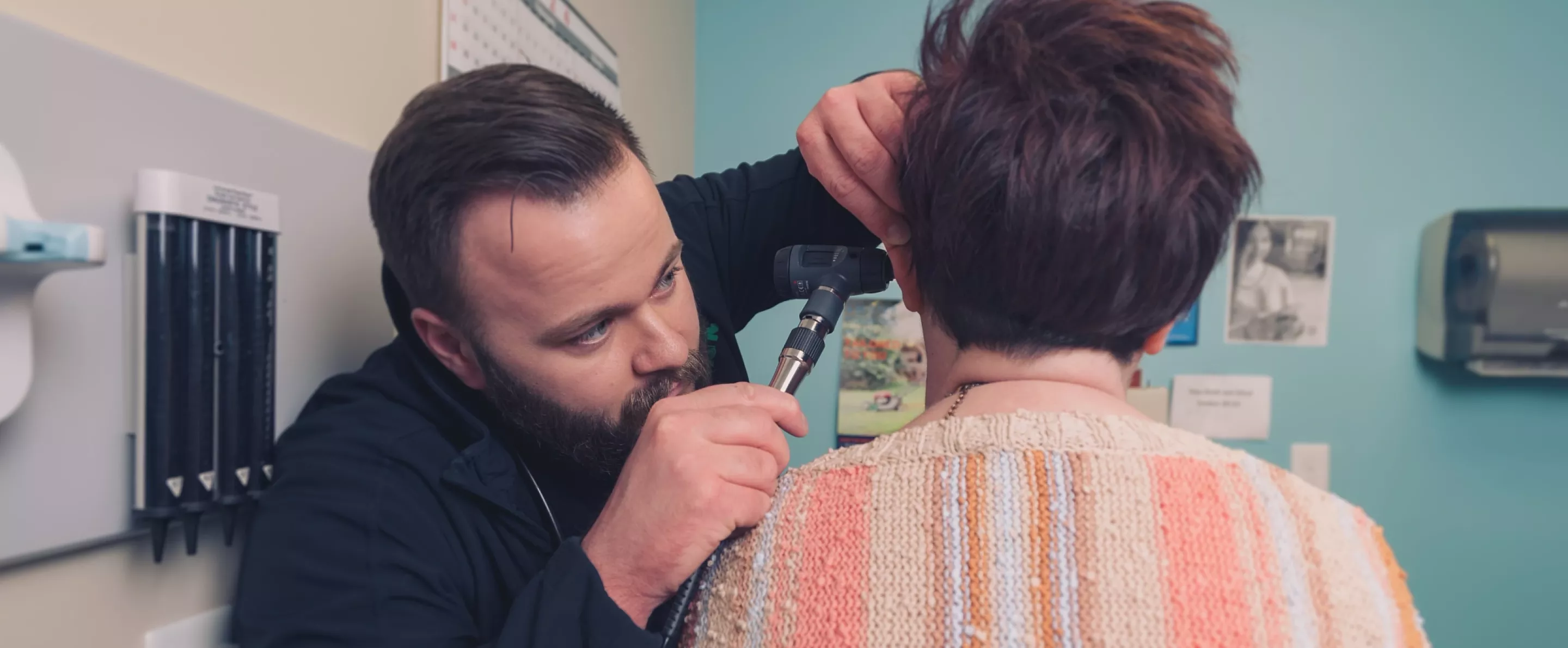 Jacob Hunter examines a patient at the Mountain Comprehensive Health Corp. center.