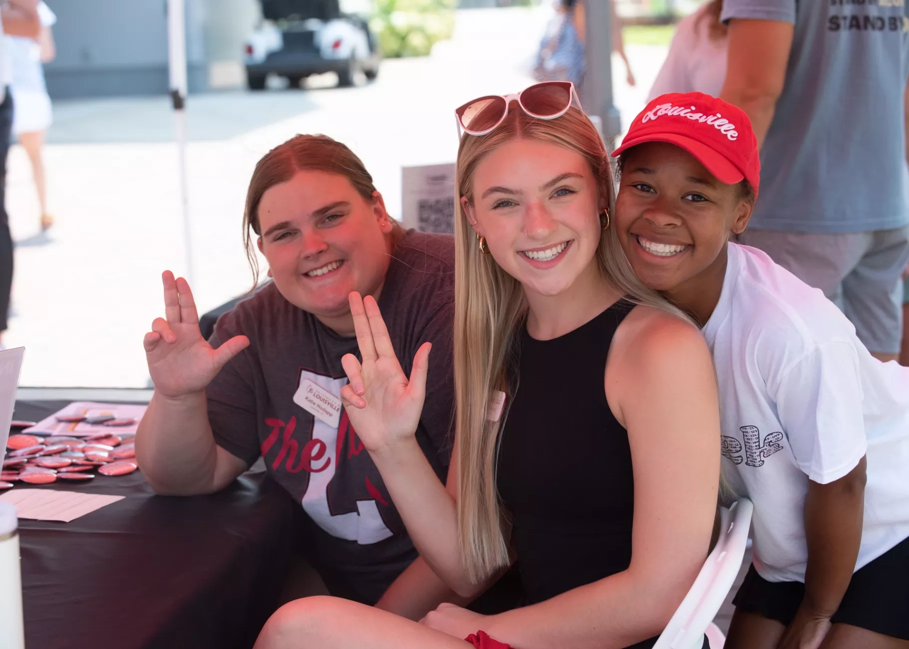 Three students smiling at the camera during Homecoming