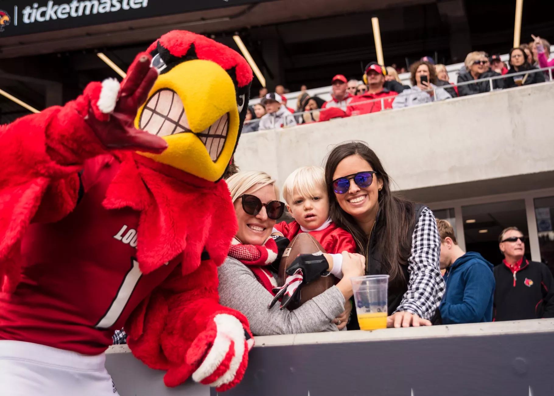 Fans watch the homecoming football game with Louie