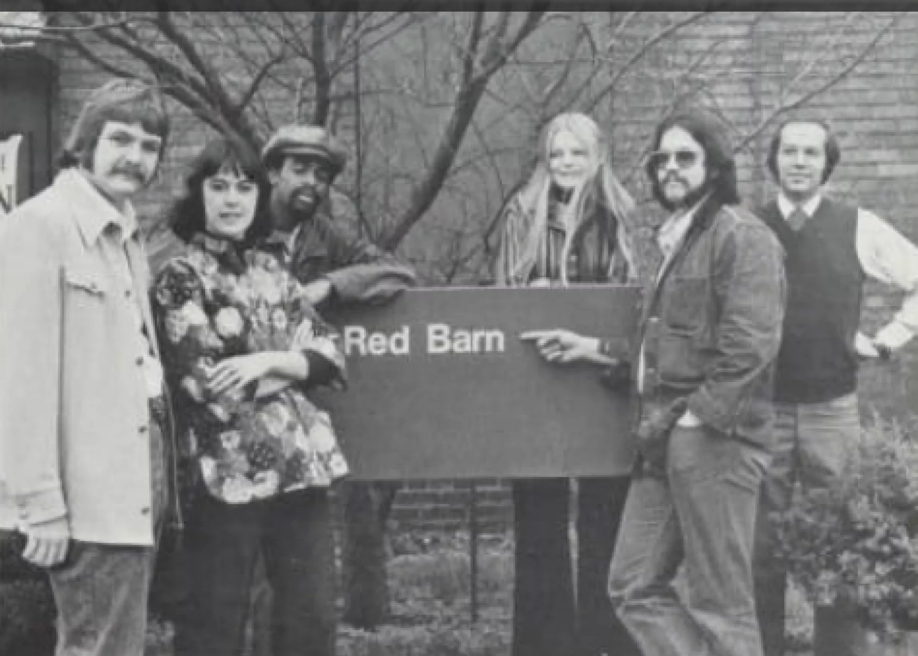 70's students posing with the red barn sign