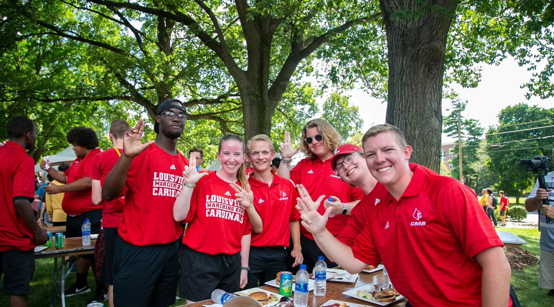 Members of the Cardinal Marching Band pose for a picture holding up their Ls.