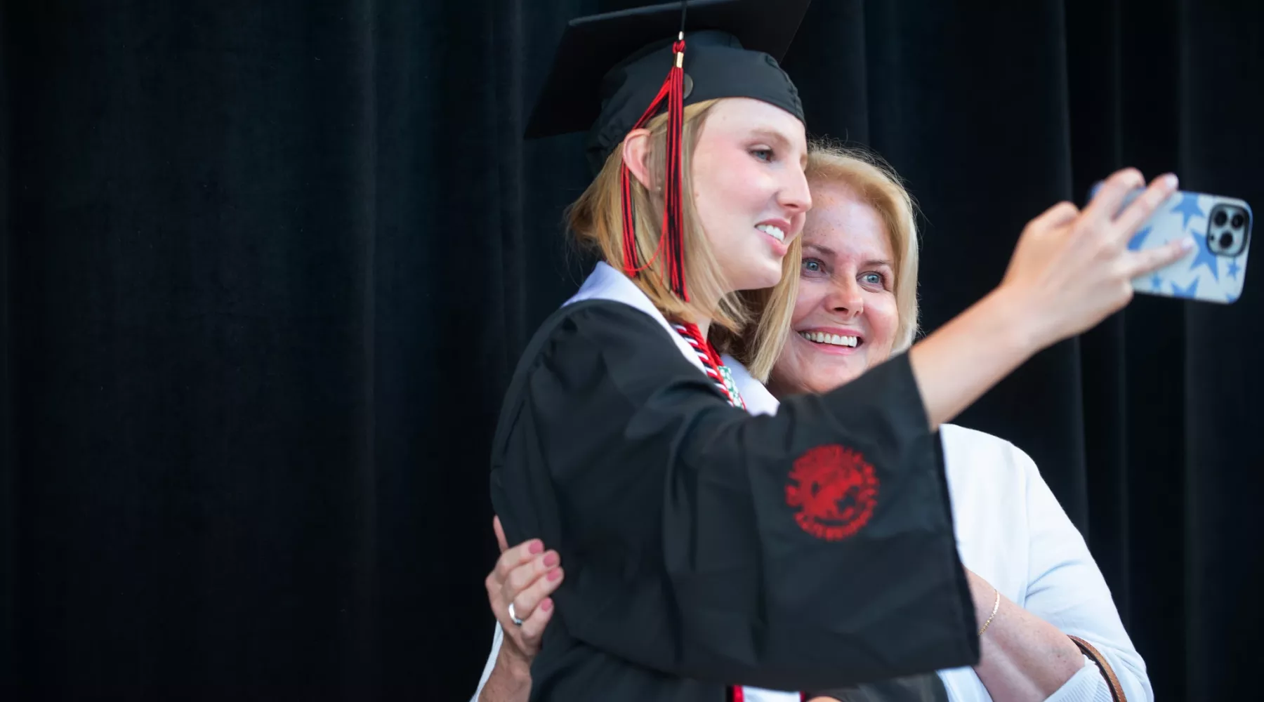 Student taking a photo with a relative at Commencement May 2022