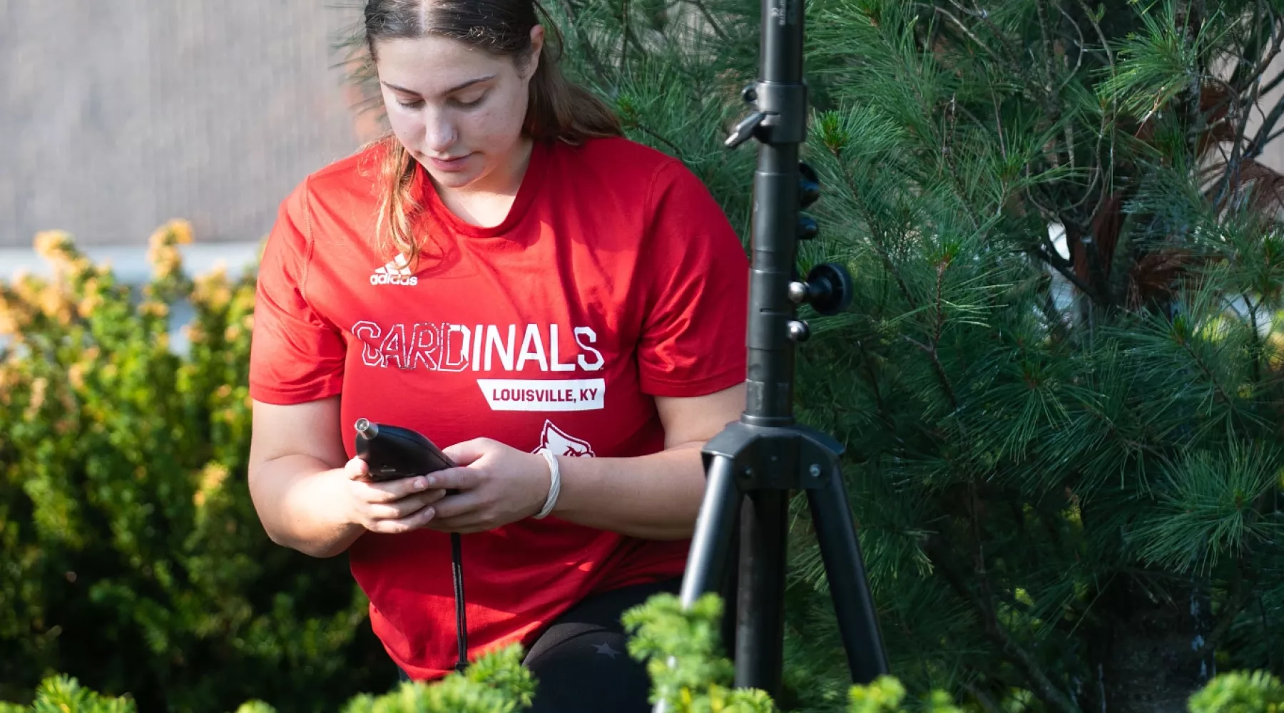 Madison Cicha sets up microphone during sound study summer research project with the Envirome