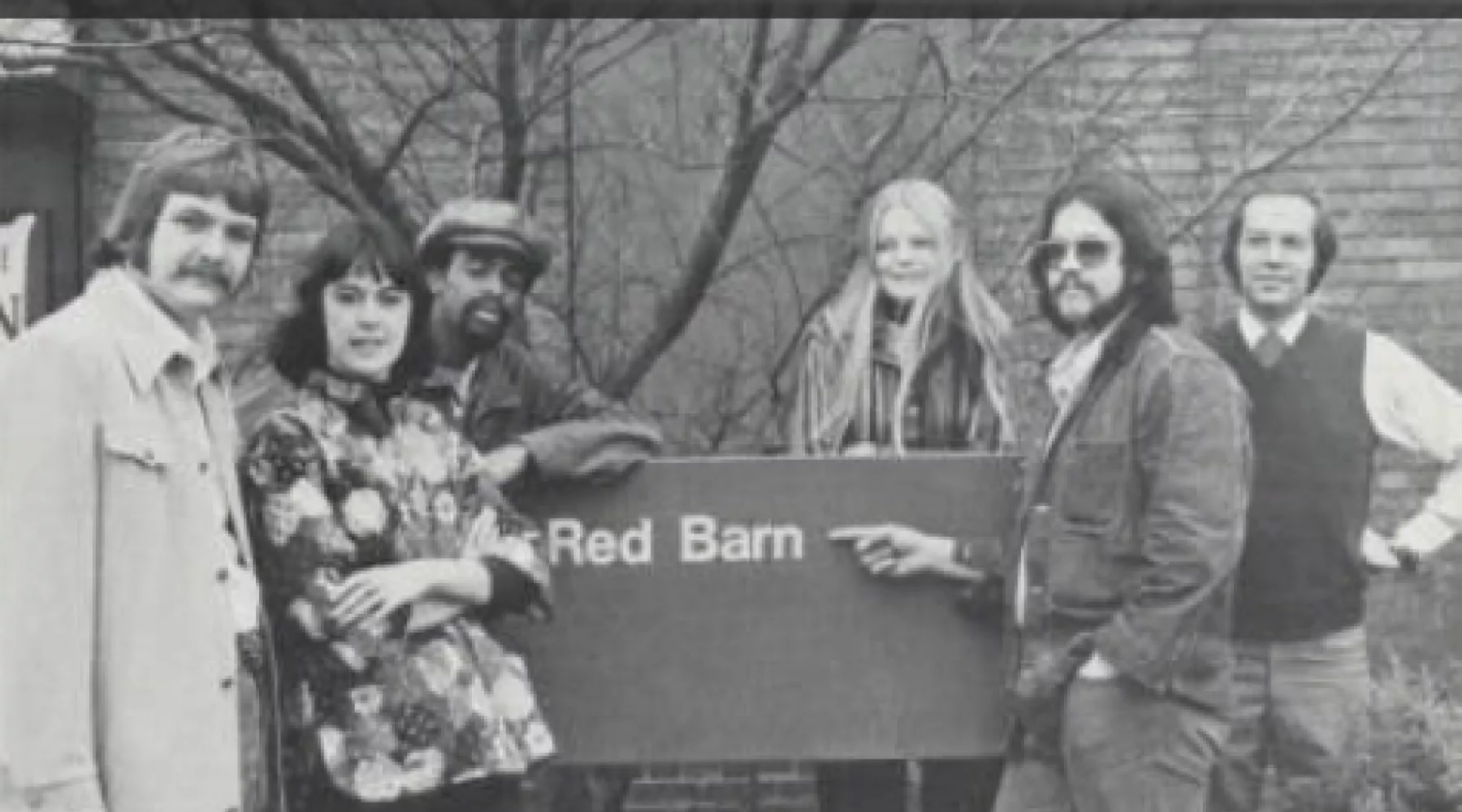 70's students posing with the red barn sign