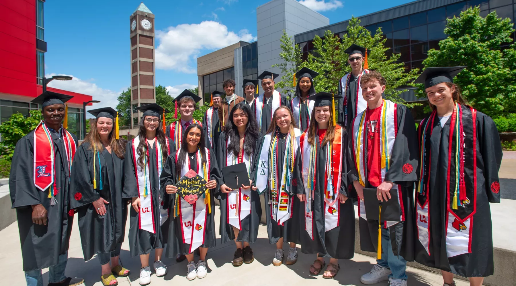 CEI graduates in robes posing outside