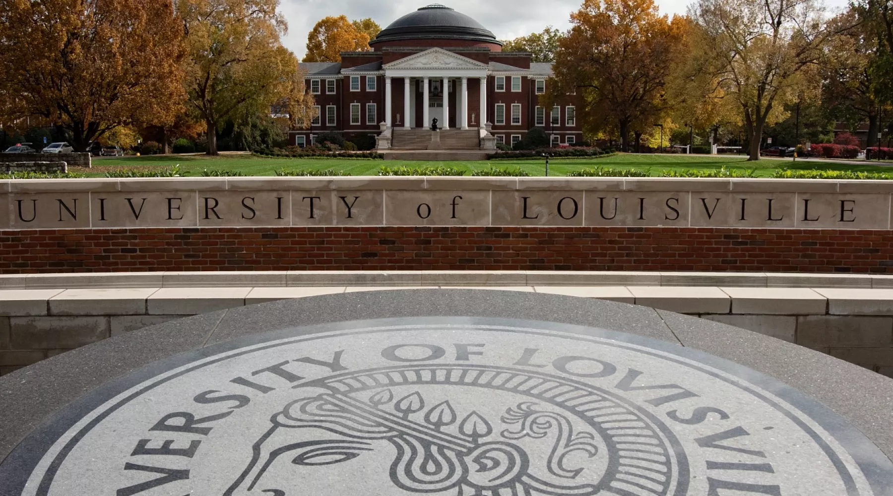 Wide-angle portrait of the exterior of Grawemeyer Hall and the Oval with the 3rd Street entrance sign and Minerva in the…