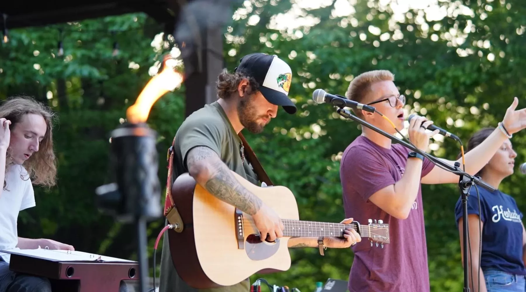 Guitar player and singer outdoors on stage at Ignite event