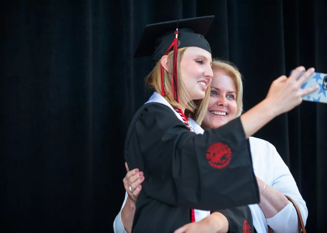 Student taking a photo with a relative at Commencement May 2022