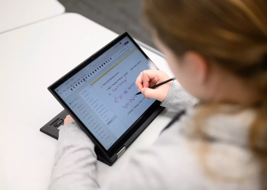 Student taking notes on a tablet in a chemistry course