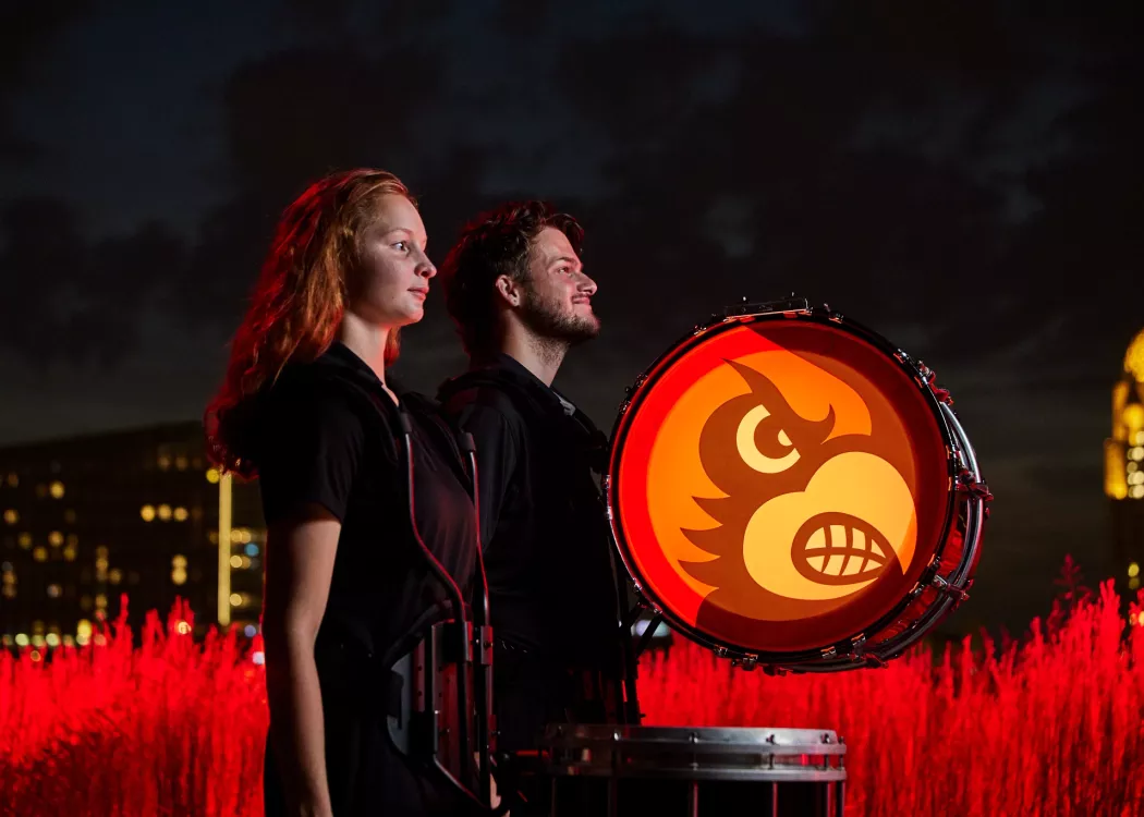 The members are standing side by side as their drums are still and waiting to played.
