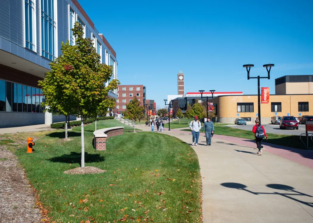 Students walking next to the Belknap Academics Building in the fall.