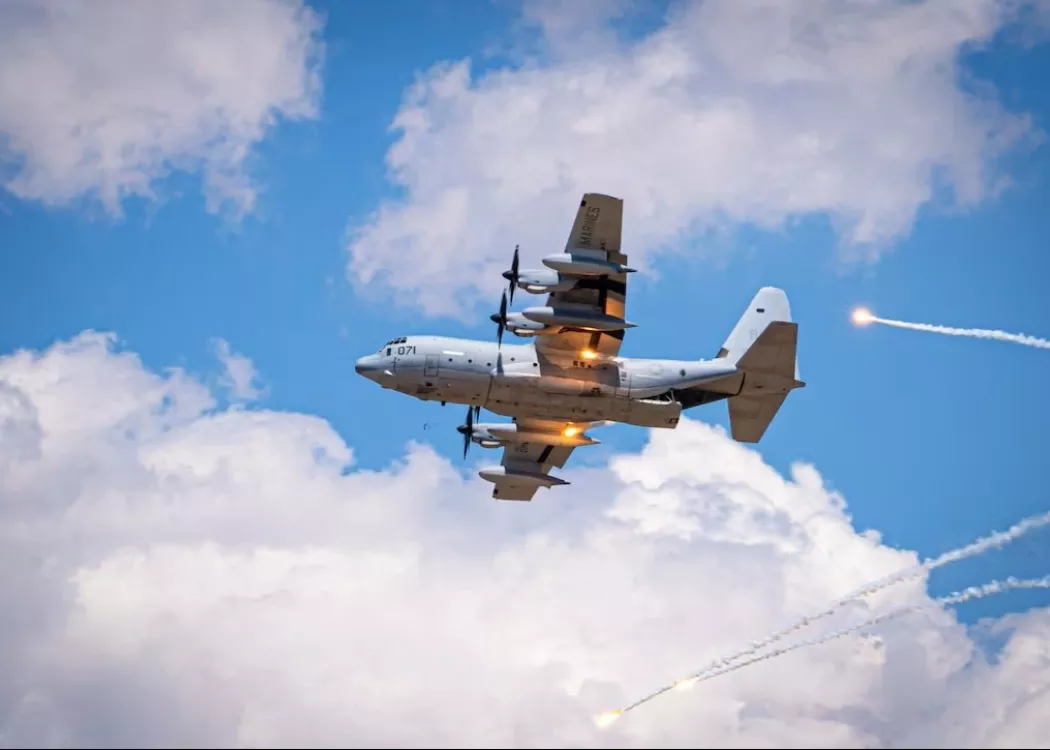 A Marine Corps KC-130J Super Hercules aircraft executes evasive maneuvers in response to a simulated threat during a…