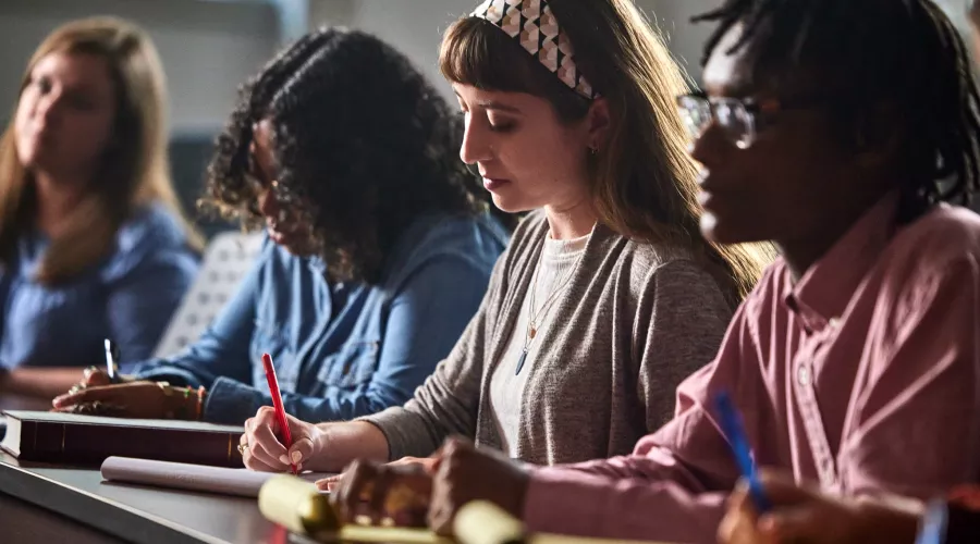 Multiple law students are listening to the lecture and engaging with the lecture through active attention and taking notes.
