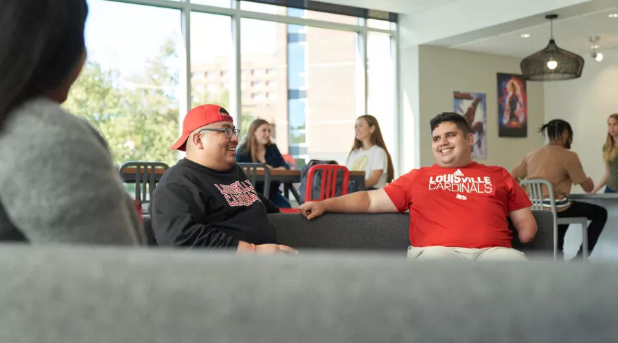 Students sitting on the couches and talking in the Belknap Residence Hall.