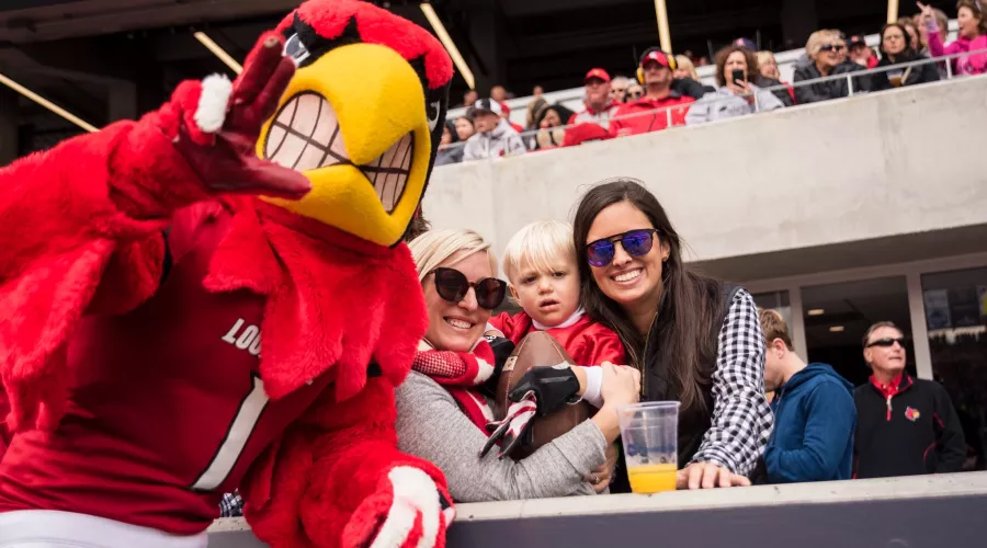 Fans watch the homecoming football game with Louie