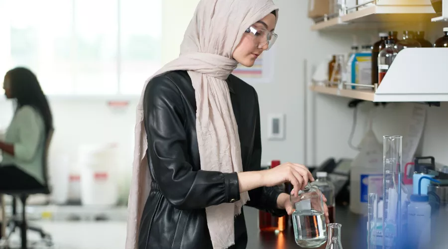 Female student performs chemistry experiment in a lab