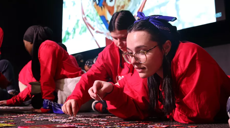 Students on the floor working jigsaw puzzles at the Cardinal Conclave
