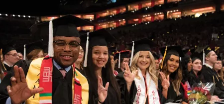 University of Louisville students at graduation holding up their L's.