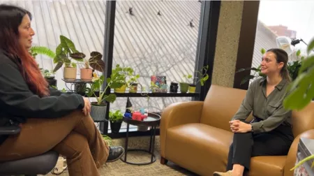 seated counselors having a discussion with plants and windows behind them